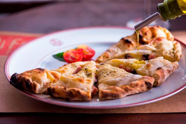 Na forma de um pastel, o calzone aperitivo tem recheio de mussarela, catupiry, presunto e azeitona Na forma de um pastel, o calzone aperitivo tem recheio de mussarela, catupiry, presunto e azeitona