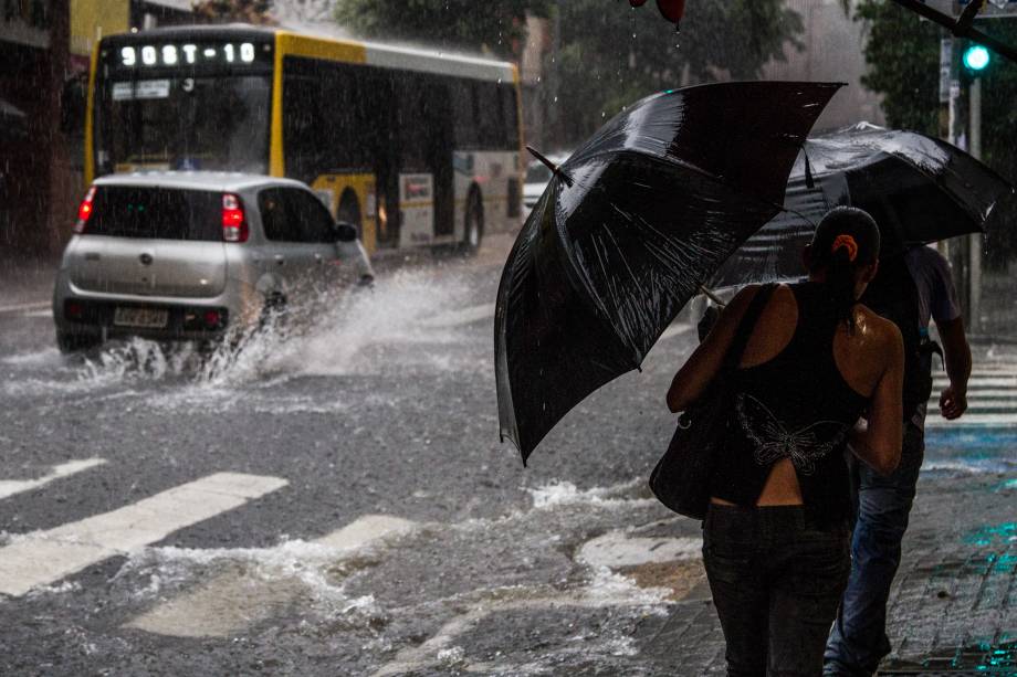 Pedestres se protegem da chuva na Rua Augusta, na região central, nesta quarta-feira (25)