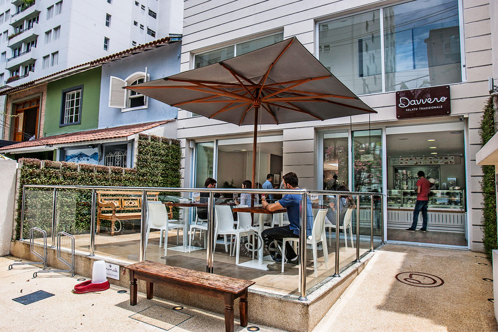 Três casas com mesas ao ar livre