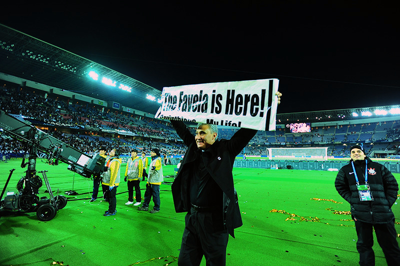 O técnico Tite ergueu a faixa "The Favela is Here"