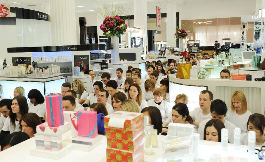 	Funcion&aacute;rios e clientes meditam juntos no meio da loja