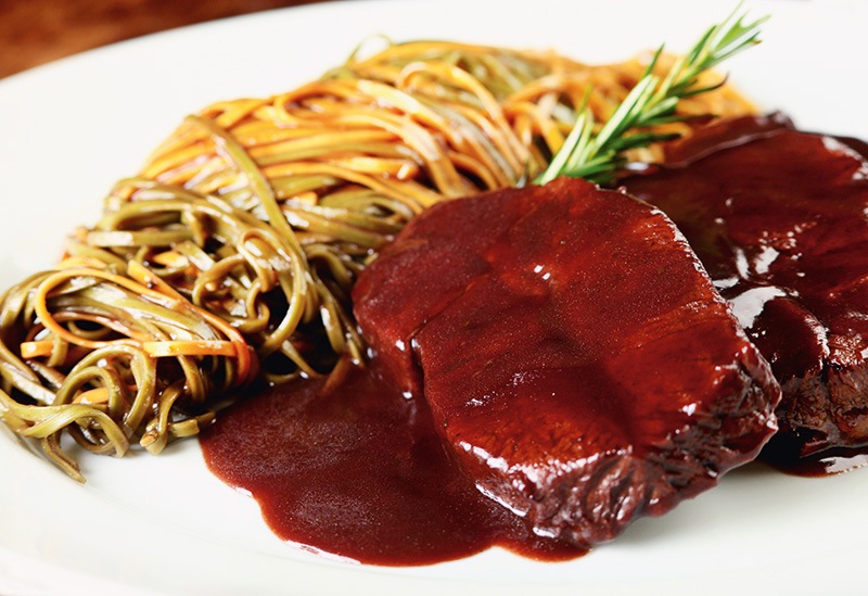 Tagliolini paglia e feno acompanhamento do brasato al vino, com duas fatias de carne cozidas no vinho tinto