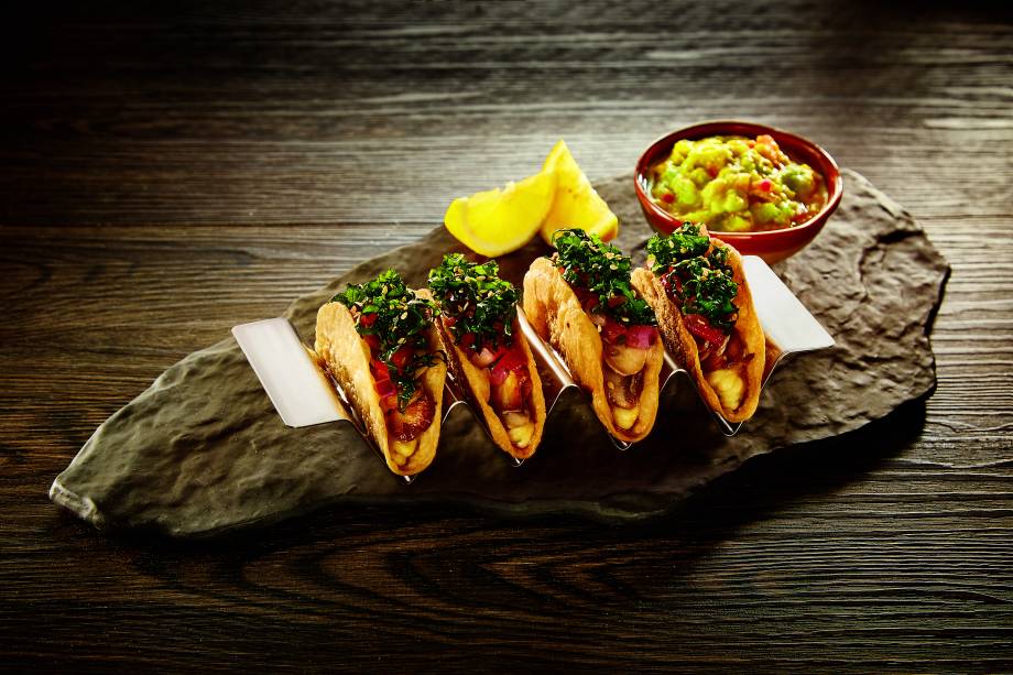 Tacos vegetarianos: recheados de cogumelo-de-paris salteado, tomate, homus e saladinha de couve, tudo temperado com limão-siciliano e acompanhado de guacamole Tacos vegetarianos: recheados de cogumelo-de-paris salteado, tomate, homus e saladinha de couve, tudo temperado com limão-siciliano e acompanhado de guacamole