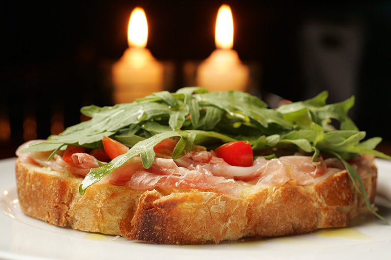 Bruschettas de presunto cru, tomate-cereja e rúcula