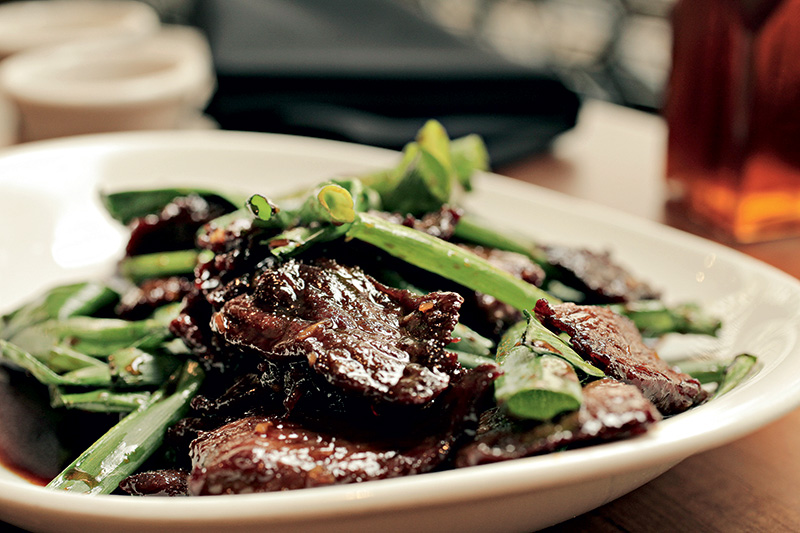 Mongolian beef traz fatias de carne na chapa carameladas no molho de shoyu e alho com cebolinha verde