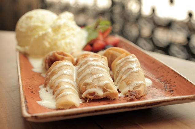 A banana caramelada é coberta por caldas de caramelo e de baunilha, servida com sorvete de abacaxi e coco A banana caramelada é coberta por caldas de caramelo e de baunilha, servida com sorvete de abacaxi e coco