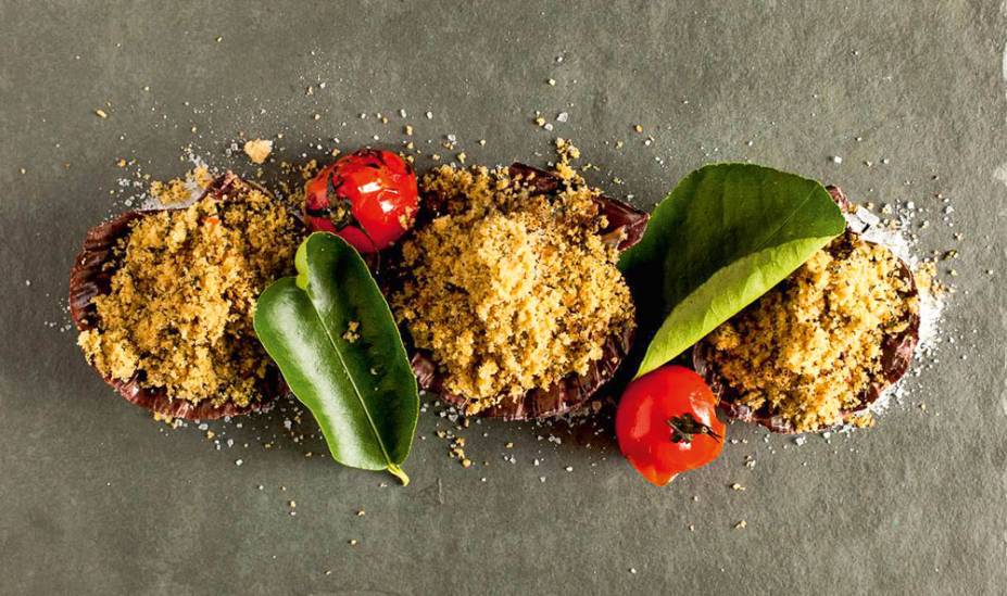 O trio de vieiras na concha ao forno a lenha é coberto de farofa de sálvia O trio de vieiras na concha ao forno a lenha é coberto de farofa de sálvia