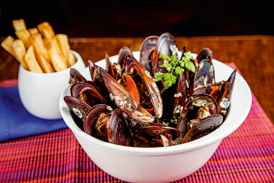 Moules frites: mexilhões num caldo aromático e acompanhados de fritas Moules frites: mexilhões num caldo aromático e acompanhados de fritas