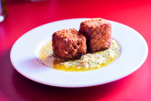 O par de croquetes de pé de porco com linguiça prepara o paladar para o próximo gole O par de croquetes de pé de porco com linguiça prepara o paladar para o próximo gole