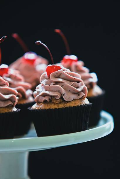 O bolinho de frutas vermelhas coroado com cereja O bolinho de frutas vermelhas coroado com cereja