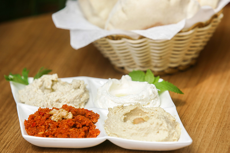 No quarteto de pastas vão muhamara (pasta de pimentão vermelho), babaganuche (berinjela), coalhada seca e homus (grão-de-bico)