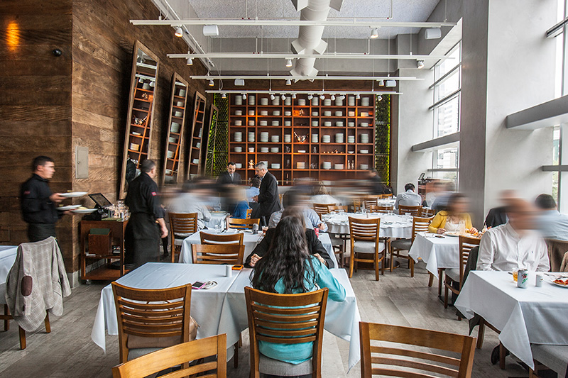 Com entrada de luz natural, o restaurante fica na sobreloja de um edifício comercial