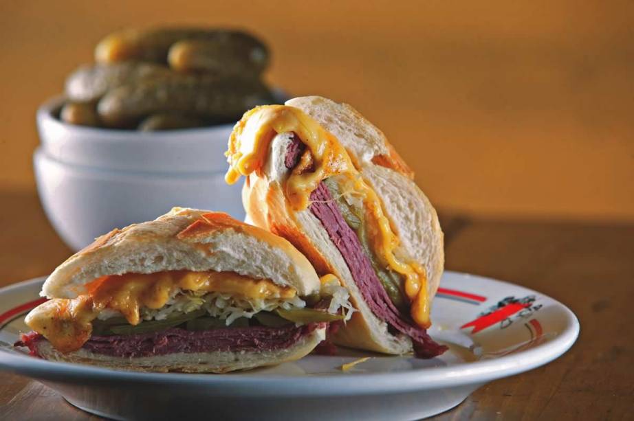 sanduíche quente de pastrami, chucrute, picles e queijo prato da Mercearia São Pedro sanduíche quente de pastrami, chucrute, picles e queijo prato da Mercearia São Pedro