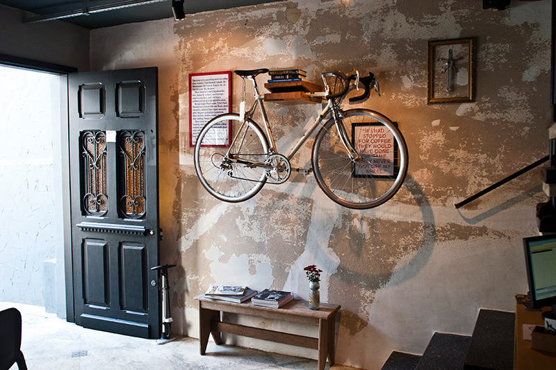 Atrás da bicicleta da decoração, um quadro divertido diz "se eu tivesse parado para tomar um café, eles nunca teriam saído da minha cola"