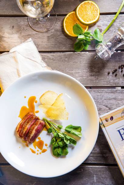 Peito de pato com a gordura bem dourada é servido com agrião e batata frita furadinha Peito de pato com a gordura bem dourada é servido com agrião e batata frita furadinha