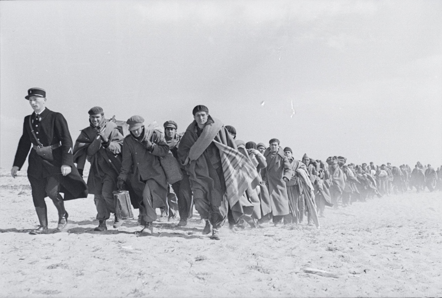 robert-capa-refugiados-andando-na-praia-campo-de-internacao-frances-para-exilados-republicanos-le-barcares-franca-marco-de-1939.jpeg