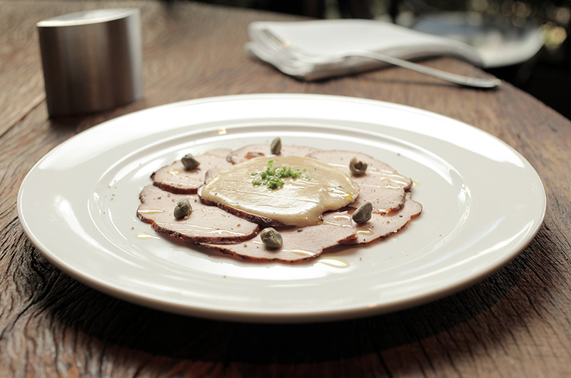 O vitelo tonnato vem regado com maionese de atum e alcaparra O vitelo tonnato vem regado com maionese de atum e alcaparra
