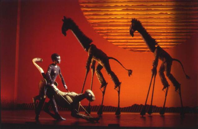 Girafas e um guepardo andam pela savana durante a apresentação da música "O Círculo da Vida" (The Tree of Life), que abre o espetáculo. Girafas e um guepardo andam pela savana durante a apresentação da música "O Círculo da Vida" (The Tree of Life), que abre o espetáculo.