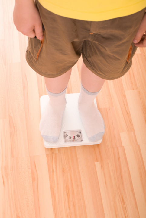 Boy measures weight on floor scales