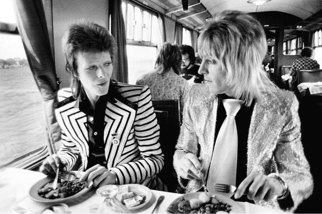 David Bowie e Mick Ronson almoçando em trem, em 1973 David Bowie e Mick Ronson almoçando em trem, em 1973