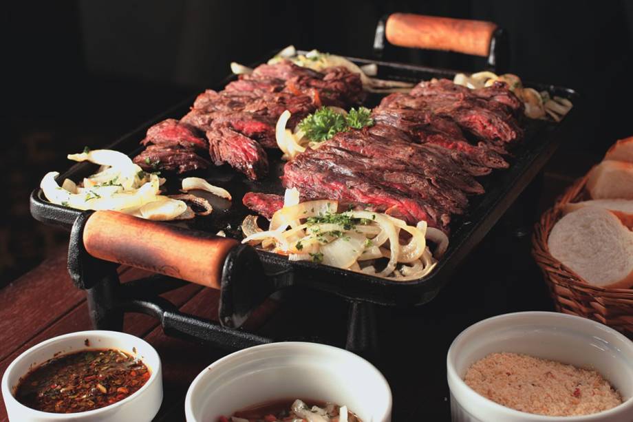 No Boteco Coutinho: a fraldinha com cebola na chapa chega acompanhada de pão, vinagrete e farofa No Boteco Coutinho: a fraldinha com cebola na chapa chega acompanhada de pão, vinagrete e farofa