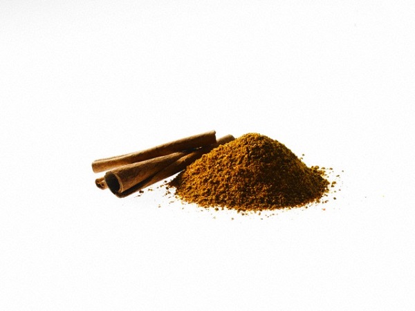 Studio shot of Ground Cinnamon and Cinnamon Sticks on white background