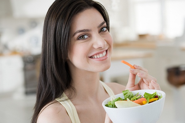 Young woman eating salad