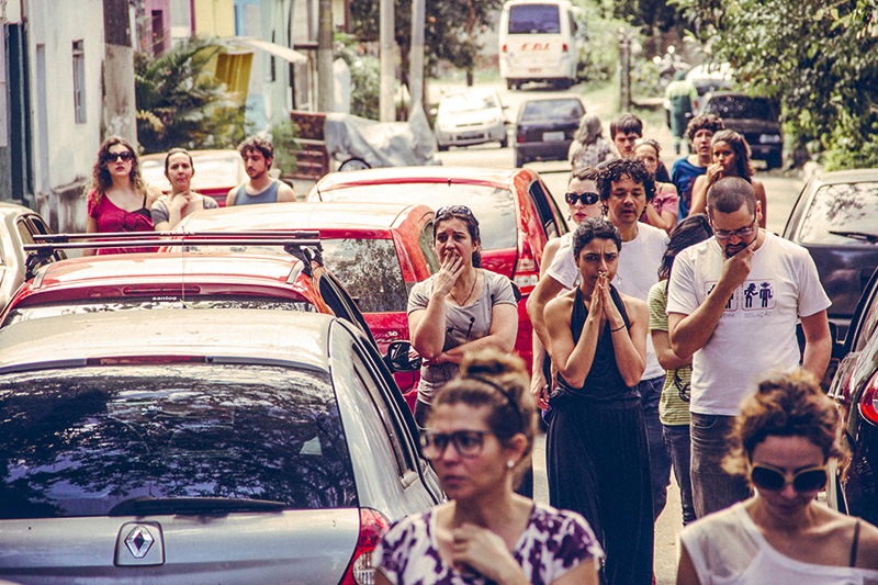 Atores e público na rodovia: espectadores se acomodam nos dezoito automóveis do cenário