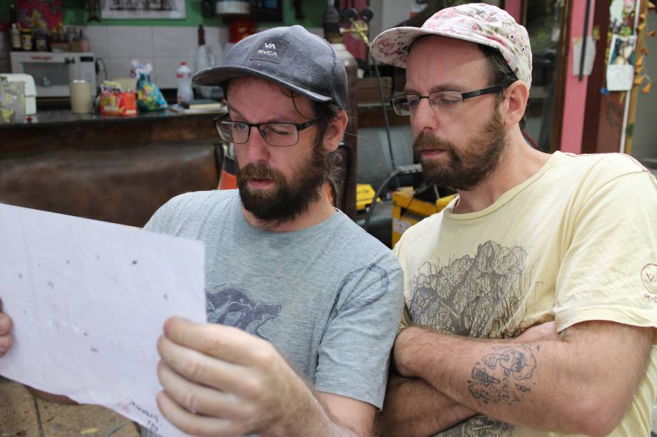 Irmãos trabalhando durante montagem da mostra