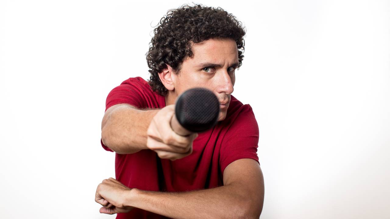 Homem aponta microfone para a frente