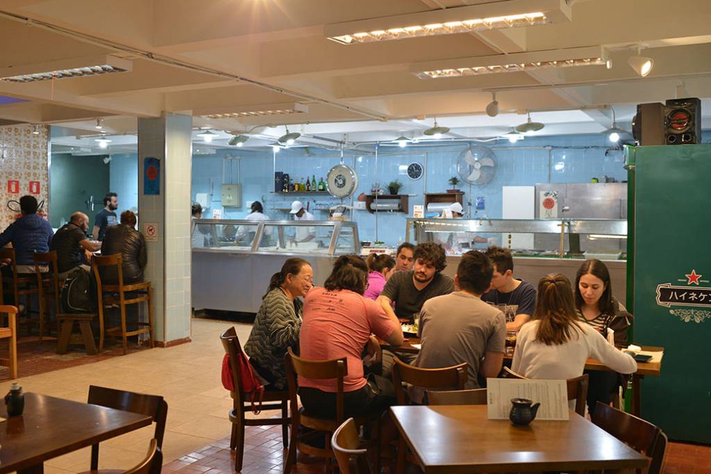 Peixaria Mitsugi Espaço de peixaria com mesas em frente, montadas como um restaurante