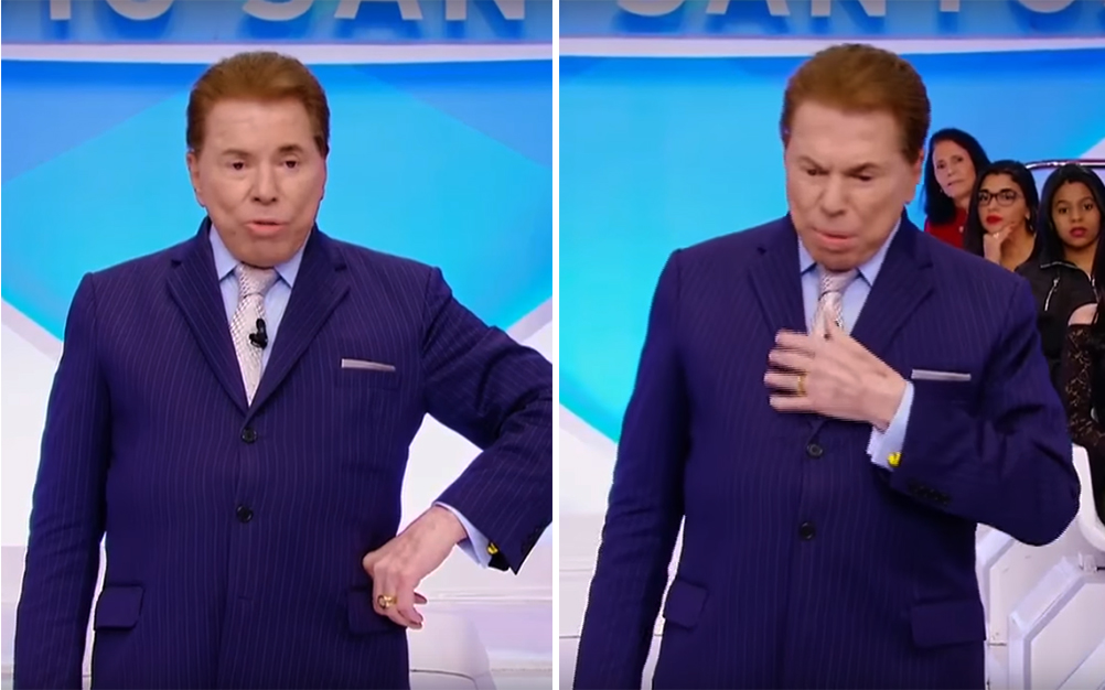 Silvio Santos dentro do auditório azul, em pé com terno