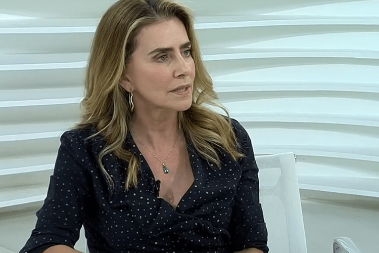 Imagem mostra atriz Maitê Proença vestindo camisa preta e olhando para a frente