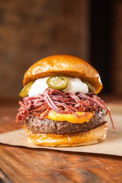 Hambúrguer jalapeño com queijo cheddar, pastrami desfiado, sour cream e fatias de pimenta Hambúrguer jalapeño com queijo cheddar, pastrami desfiado, sour cream e fatias de pimenta