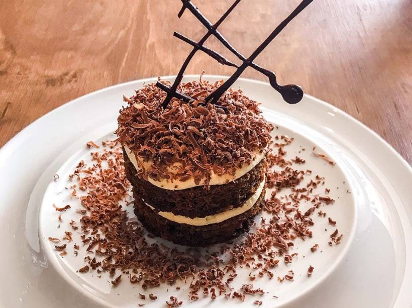 Releitura de tiramisu: bolo de café embebido em calda de café e licor 43, finalizada com creme de mascarpone, baunilha e raspas de chocolate ao leite