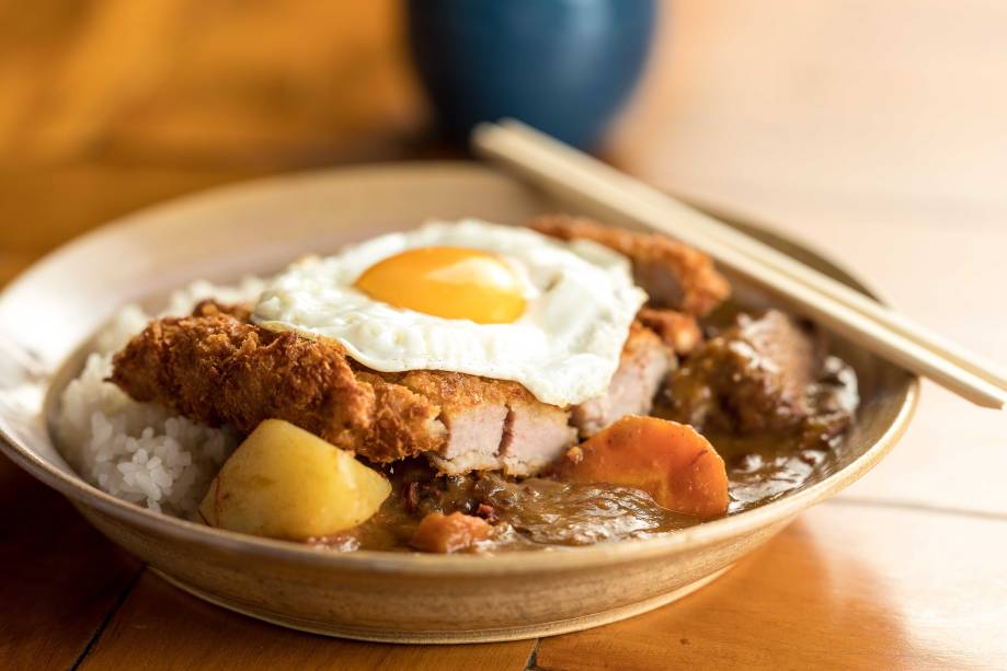 Tonkatsu kare à cavalo: lombo suíno empanado com molho de curry, arroz e ovo frito Tonkatsu kare à cavalo: lombo suíno empanado com molho de curry, arroz e ovo frito