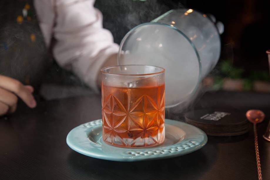 Back in black: defumado com canela, a mistura lembra um negroni e leva gim, vermute tinto e Aperol Back in black: defumado com canela, a mistura lembra um negroni e leva gim, vermute tinto e Aperol