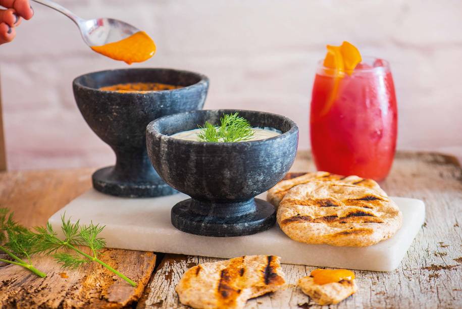 Dupla de tirokafteri e tzatziki: pastas de queijo feta com pimentão e de pepino com iogurte e pão pita Dupla de tirokafteri e tzatziki: pastas de queijo feta com pimentão e de pepino com iogurte e pão pita