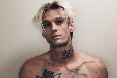 Homem branco com pescoço e peito tatuados