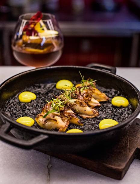 Fideuà, macarrão fininho cozido aqui com tinta de lula: servida com o molusco grelhado Fideuà, macarrão fininho cozido aqui com tinta de lula: servida com o molusco grelhado