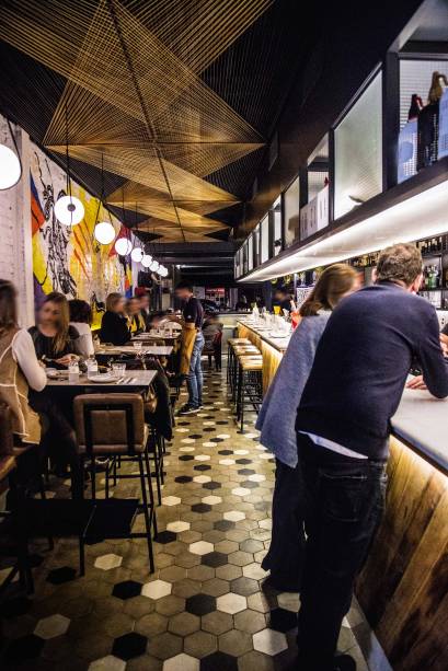 Tinindo: o salão alto-astral conta com mesas elevadas, um extenso balcão e cozinha à mostra Tinindo: o salão alto-astral conta com mesas elevadas, um extenso balcão e cozinha à mostra