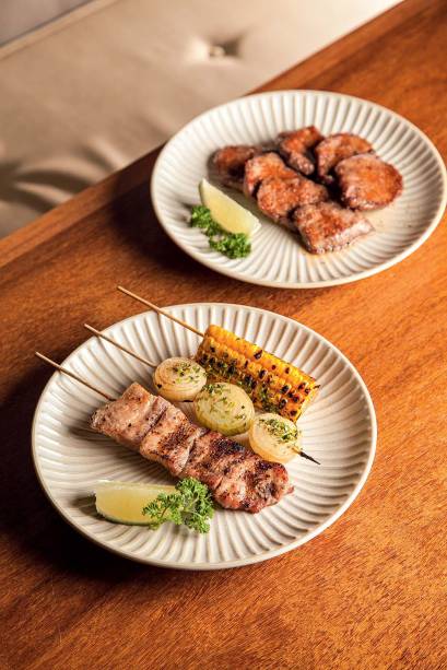 Petiscos que saem da churrasqueira: língua, milho, cebola e barriga de porco Petiscos que saem da churrasqueira: língua, milho, cebola e barriga de porco