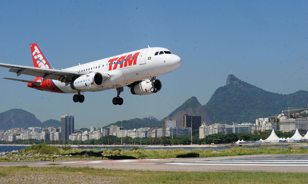 Avião, ainda no ar, pousando em uma pista