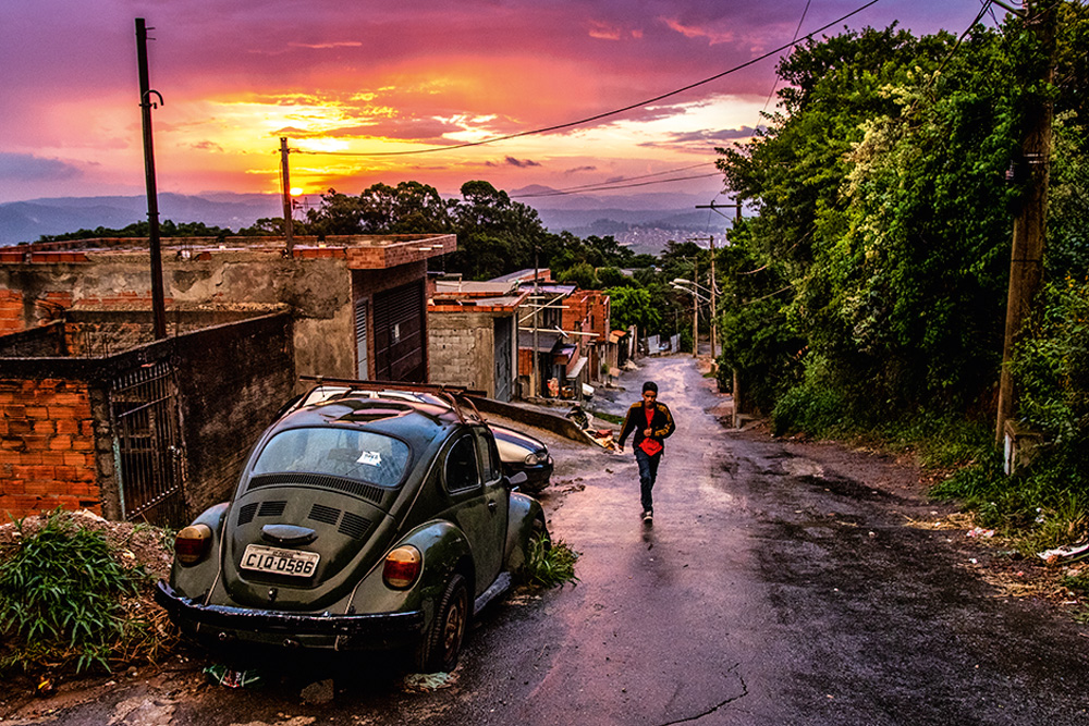 2M6A9994.jpg Ladeira da ZN, uma pessoa desce a rua com uma mochila durante o pôr do sol