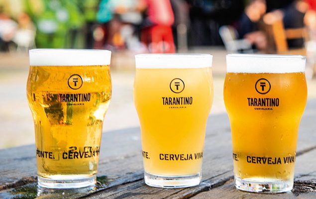 Veja Comer e Beber Bares – CERVEJARIA TARANTINO 001.jpg Três tulipas com chope claro enfileirados.
