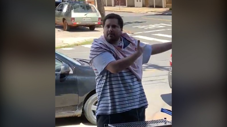 Imagem mostra Mateus Couto em frente ao estabelecimento enquanto um dos funcionários grava as ofensas do homem como celular