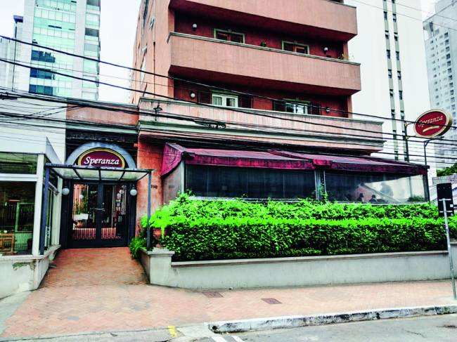 Speranza Moema Fachada de prédio com jardim avarandado na frente e pizzaria Speranza no térreo.