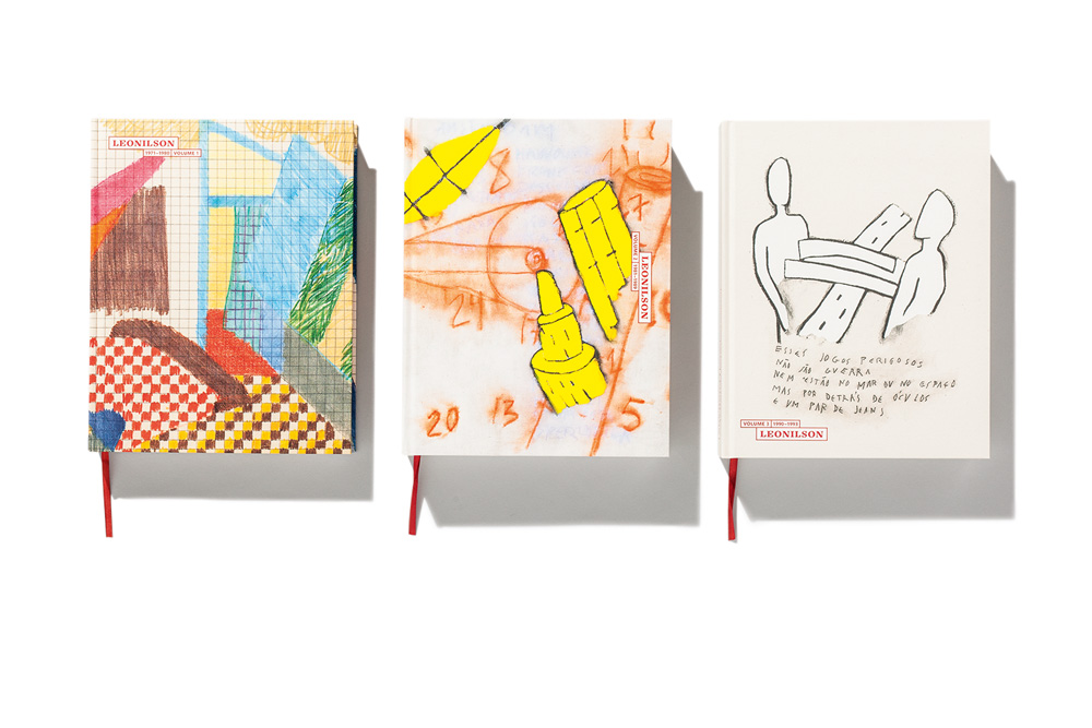 leonilson02.jpg 3 livros um ao lado do outro. Um tem capa abstrata e colorida, outra é amarela e laranja, com números e formas abstratas e a terceira tem desenho de um corpo entrelaçado com uma estrada