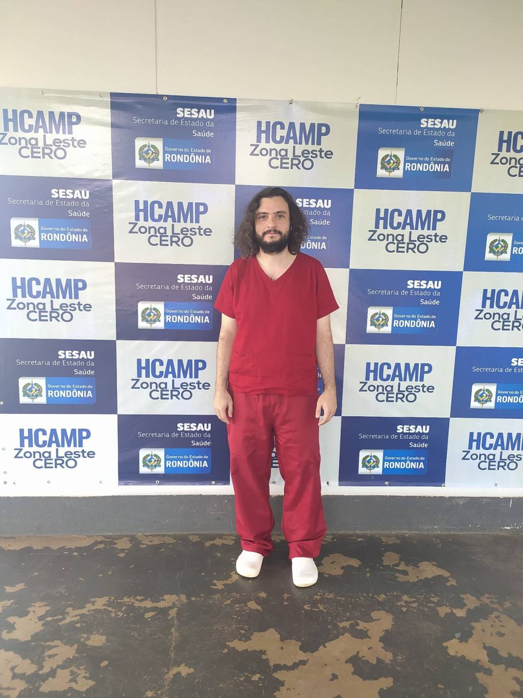 luís gonçalves moreira Imagem mostra Luís sorrindo na frente de banner que diz: HCAMP Zona Leste CERO