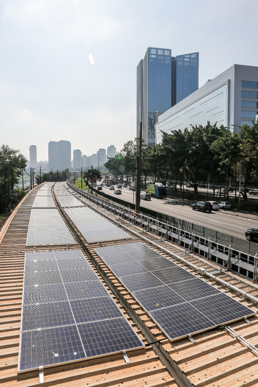 Estação Sustentável CPTM Vila Olímpia_Placas Fotovoltaicas_Divulgação Santander a imagem mostra placas fotovoltaicas acima do teto da estação vila olímpia, com a cidade no fundo